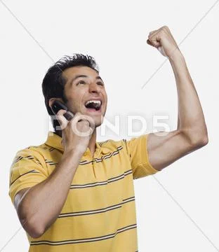 Close-up of a man talking on a mobile phone and clenching fist Stock Photos