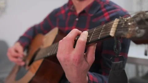 Close-up of man teaching guitar chords at home, tutorial style 스톡 동영상 315066032