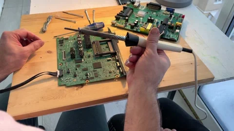 Close-up of a man teaching his boy at home to solder computer spare parts. Stock Footage 258427124