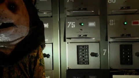 Close-up of Man with a teddy bear head standing in the basement with electric Stock Footage 125005690