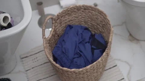 Close-up, a man throwing dirty clothes into a laundry basket Stock Footage 263193603
