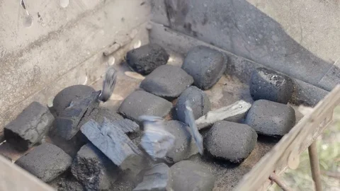 Close up man throws black coal into a barbecue. 4K footage Stock Footage 127359564