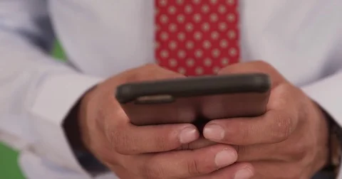 Close up of man with tie sms texting on smartphone on green screen Stock Footage