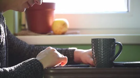 Close-up man touches screen of smartphone and drinks hot tea, morning breakfast Stock Footage 262431535