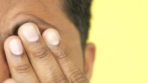 Close up of man touching his eye and forehead with fingers in studio. Stock Footage 332783317