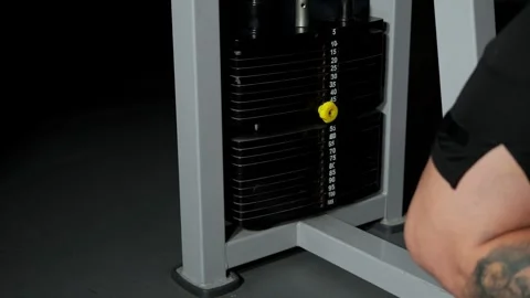 Close-up of a man training on a simulator in a gym, the movement of weights Stock Footage 295189999