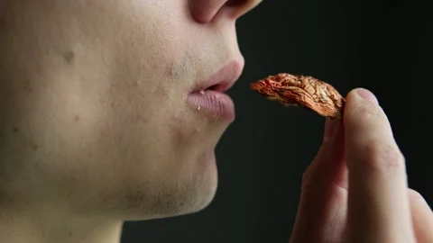 Close-up, man treatment a microdose of fly agaric, eat a hat dried red amanita m Stock Footage 297622924
