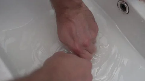 Close-up, a man trying to clear a blockage in a sink with a cable Stock Footage 262989811