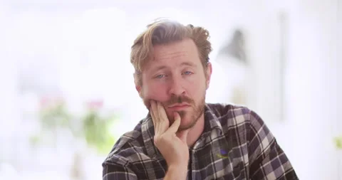 Close up man trying to look interested during very boring video call Video stock 301249736