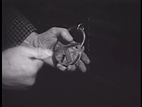 Close-up of man trying to open padlock with skeleton keys, 1950s Stock Footage 64630059