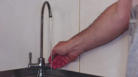Close-up of a Man Turning Off the Kitchen Tap After Filling a Glass of Water 库存影片 337429795