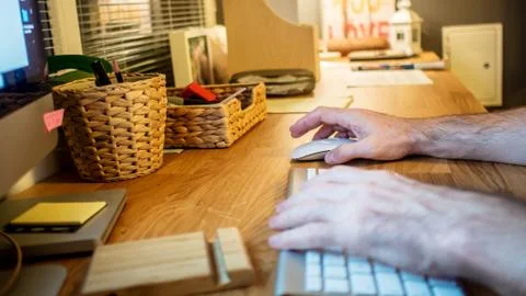 Close-up of a man typing on the keyboard of computer in the evening in the ho Stock Photos