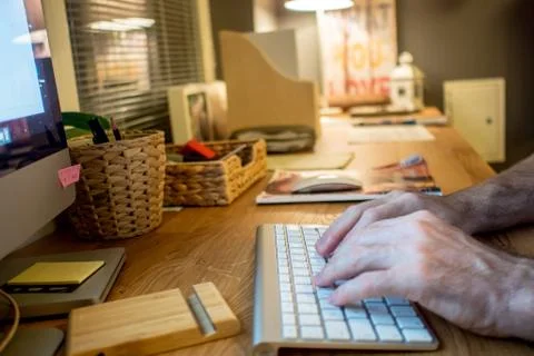 Close-up of a man typing on the keyboard of computer in the evening in the ho Stock Photos