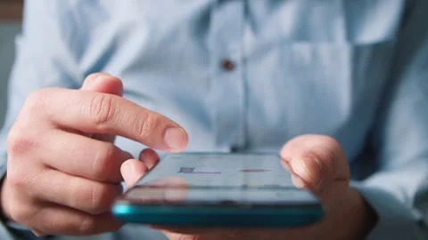 Close-up Man is typing text messages on a mobile phone while sitting at home Stock Footage 263508982