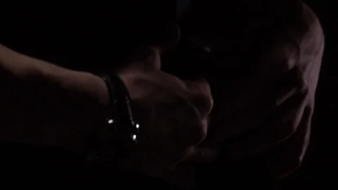 Close up of a man unbuttoning his vest, with low lighting, slow motion Stock Footage 101149953