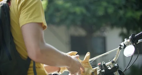 Close up of man undressing motorcycle gloves in slow motion, Japan Stock Footage 124695831