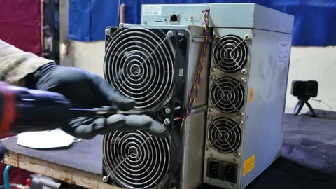 Close up man Use a cordless drill to dismantle a bitcoin mining machine Stock Footage 327438822