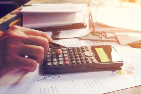 Close up man using calculator and doing finance in home office. Stock Photos