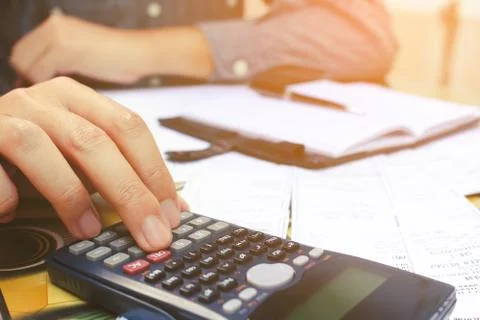 Close up man using calculator  in home office. Stock Photos