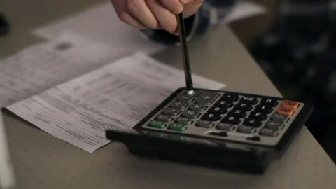 A close up of a man using calculator. Work from home. Calculation of big numbers Stock Footage 149596438