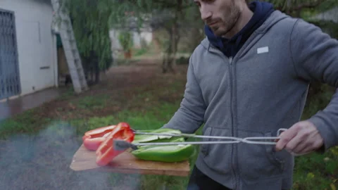 Close up of man using cooking clamps to put the vegetables on the grill - Stock Footage 208328396