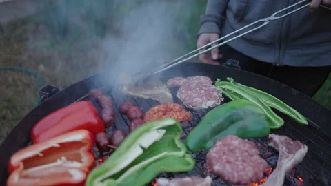 Close up of man using cooking clamps to turn the meat over - slow motion shot Stock-Footage 209549235