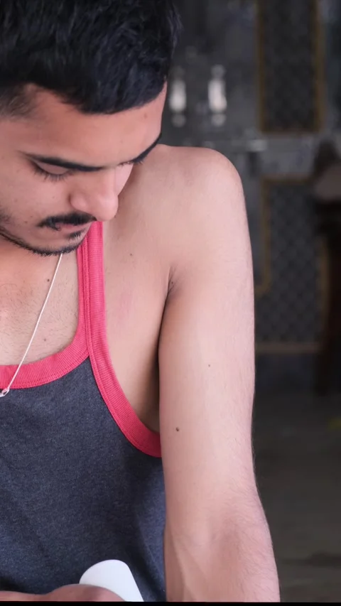 Close up of man using electric massage gun on arm for muscle recovery Видео 331063087