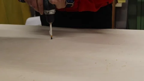 Close-up of man using electric screwdriver to drive screw into wooden board. DIY Stock Footage 327973753