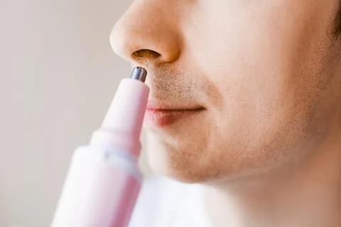 Close-up of a man using an electric trimmer for nose hair removal. A daily .. Stock Photos