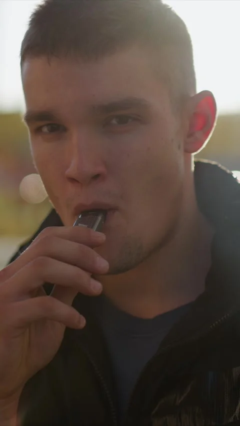 Close up of man using electronic vaping device with visible vapor in soft Vídeo Stock 345059973