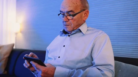 Close up of man using his smart phone in horizontal position at home Stock Footage 99015210