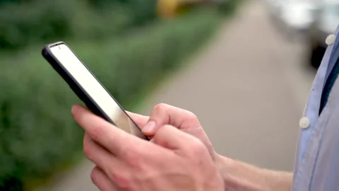 Close-up of a man using his smartphone and smiling outdoors Stock Footage 220550745