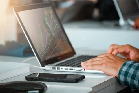 Close up of man using laptop trading stock exchange market in coffee cafe Stock Photos