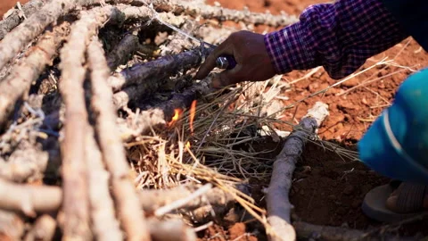 Close up Man using lighter light up the cassava rhizome on red dirt slow motion Stock-Footage 156230139