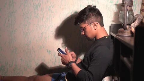 Close up of a man using mobile in the night in a dark room with a table lamp  Stock Footage 147237445