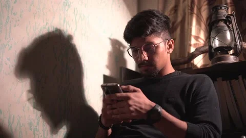 Close up of a man using mobile in the night in a dark room with a table lamp  Stock Footage 147237470