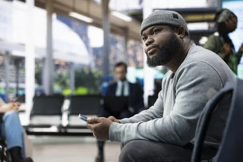 Close up of man using mobile phone on bus stop bench Stock Photos