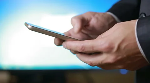 Close up of a man using mobile smart phone. the background monitor Stock Footage 68995809