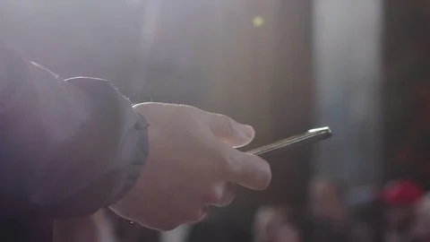 Close up of a man using mobile smart phone and the sun shines with lense flare Stock Footage 82850523