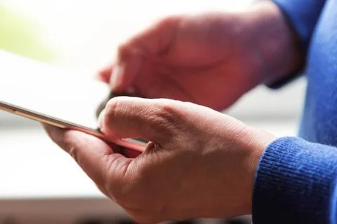 Close up of a man using mobile smart phone near the window Stock Photos