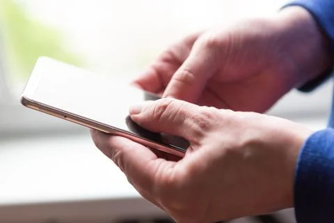 Close up of a man using mobile smart phone near the window Stock Photos