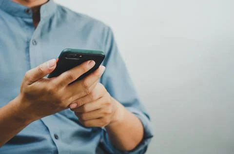 Close up of a man using mobile smart phone searching internet, sending sms, u Stock-Fotos
