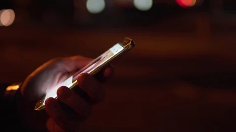Close Up Of A Man Using A Modern Curved Edge Mobile Phone At Night In A City Stock Footage 79753259