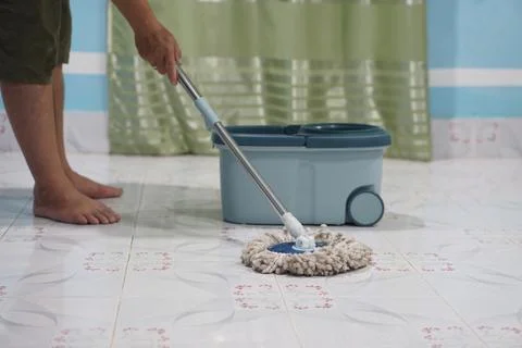 Close up of man using a mop to mop the floor. Stock Photos