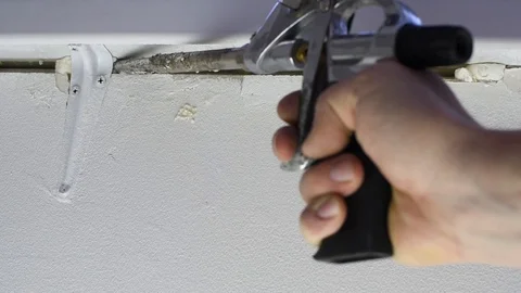 Close-up of a man using a mounting foam material from a pistol under pressure Stock Footage 118373029