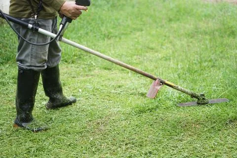 Close up  man is using mowing machine to mow the lawn in his garden. Stock Photos