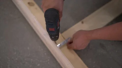 Close up of the man using power tool screwing bolts in the wooden frame Stock-Footage 152363464