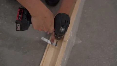 Close up of the man using power tool screwing bolts in the wooden frame Video stock 152364200