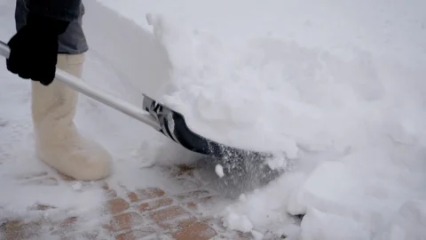 Close Up Of A Man Using A Shovel To Clean Snow Sidewalks After Snowfall Video stock 101641036