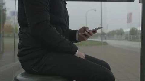 Close-up of a man using smart phone at a bus stop Stock Footage 68679164